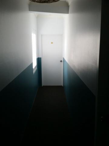 A hotel room doorway at the end of a corridor.